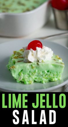 lime jello salad with whipped cream and cherries on top in front of a white plate