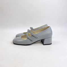 Introducing our Gray Leather Mary Jane Pumps, a perfect blend of classic elegance and modern design. Crafted from premium gray leather, these pumps feature two chic arch straps that provide both style and a secure fit. The covered leather heels, measuring a comfortable 4.5 cm, add a touch of sophistication while ensuring ease of wear. Ideal for both professional and casual settings, these Mary Jane pumps offer versatility and timeless charm, making them a staple in any woman's shoe collection. Y Elegant Gray Spring Heels, Elegant Gray Block Heel Heels, Elegant Gray Round Toe Heels, Gray Leather Block Heel Shoes, Chic Gray Block Heel Shoes, Gray Leather Block Heels, Gray Leather Block Heel, Elegant Silver Court Shoes For Office, Elegant Gray High Heels