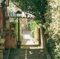 an alley way with steps leading up to a lamp post