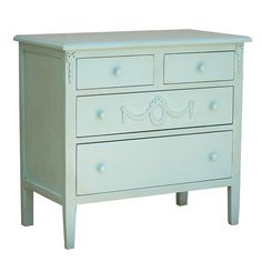 a white dresser with two drawers on one side and an ornate design on the other