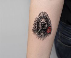 a black and white dog with a flower in its mouth tattoo on the left arm