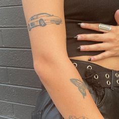 a woman with tattoos on her arm holding a cell phone