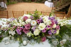 a table topped with lots of purple and white flowers