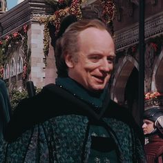 a man dressed in medieval clothing standing next to a building