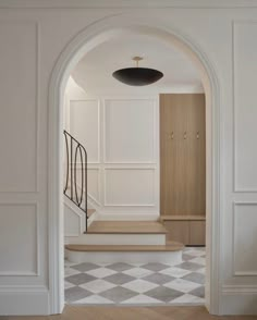 an open doorway leading to a hallway with white walls and checkered tile flooring