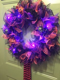 a purple and black wreath with lights on it