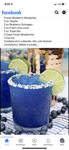 two blue margaritas with lime slices on the rim