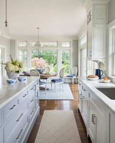 a large kitchen with white cabinets and counter tops