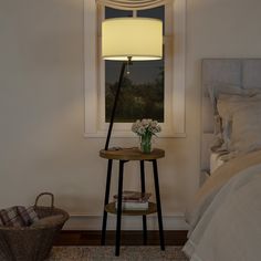 a bed room with a neatly made bed and a night stand next to a window