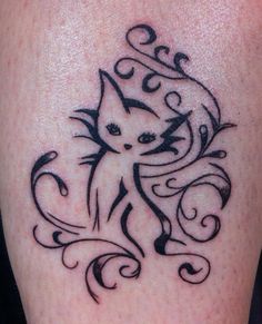 a cat tattoo on the back of a woman's leg, with swirls