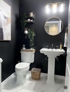 a white toilet sitting next to a sink in a bathroom under a mirror and lights