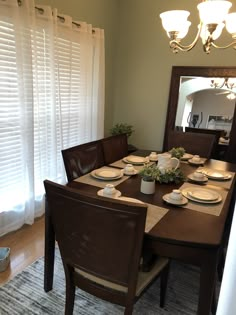 the dining room table is set with plates and place settings for six people to eat