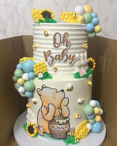 a baby shower cake is decorated with sunflowers and other decorations, including an elephant