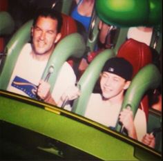 two men are riding in a roller coaster