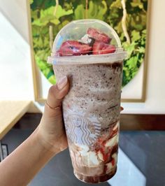 a hand holding up a starbucks drink with strawberries in it and the text, 23 secret menu frapuccinos to order at starbucks