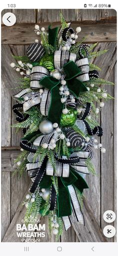 a green and white christmas wreath hanging on a wooden door with the words, baaam