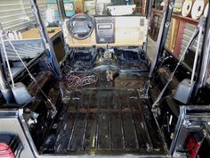 the interior of an old truck with its door open and steering wheel in place on the floor