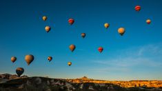 many hot air balloons are flying in the sky