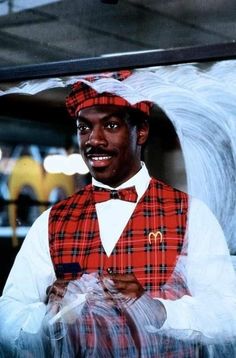 a man wearing a red and black plaid vest with a mcdonald's logo on it