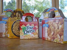 four boxes of food sitting on top of a table next to each other in front of a window