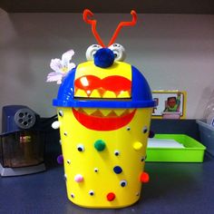 a yellow toy with eyes and mouth on top of a table