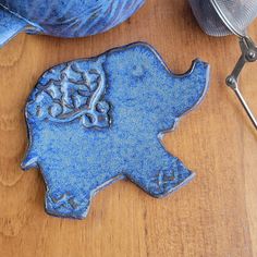 an elephant cookie sitting on top of a wooden table next to a pair of scissors