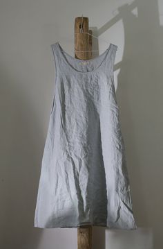 a white dress hanging on a wooden stick