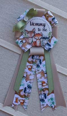 a ribbon with an image of animals on it and the words mommy to be printed on it