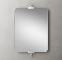 a mirror mounted to the side of a wall with a clip on it's edge