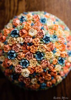 an arrangement of colorful flowers on top of a wooden table