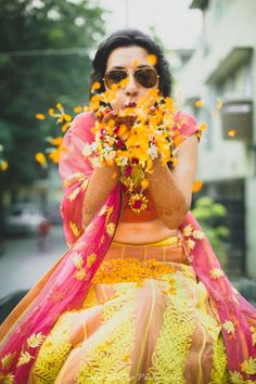 a woman with flowers in her hands and the caption below reads blowing or throwing petals into the camera