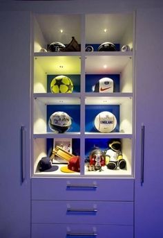 a white cabinet filled with lots of different sports related items on top of it's shelves