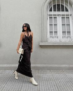 Woman walking confidently in a long black dress paired with white boots, creating a bold yet elegant look Black Dress White Boots, Style Black Dress, Black Dress Style, Monochrome Outfit, White Boots, Modern Vibe