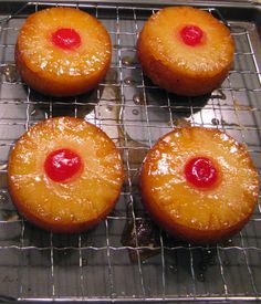 four pineapple upside down cakes cooling on a rack