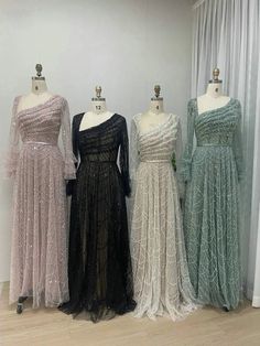 three dresses on mannequins in front of curtains