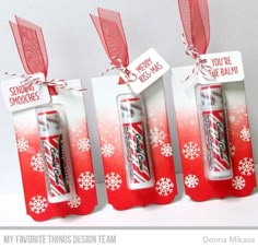 three red and white tags with snowflakes on them, one has a tube of toothpaste in it