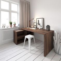 a white room with a wooden desk and two pictures on the wall next to it