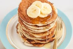 a stack of pancakes topped with bananas and syrup