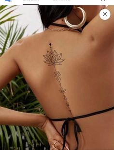 the back of a woman's body with tattoos on it