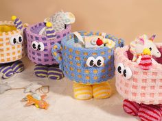 three knitted toys are sitting on a white surface, one has an owl and the other is a bird