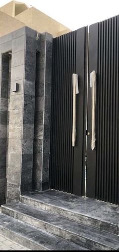 an entrance to a building with black and grey marble steps leading up to it's doors