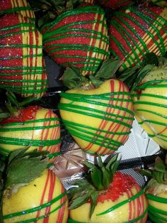 strawberries with green and red stripes are stacked on top of each other in a pile