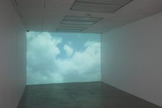 an empty room with clouds in the sky