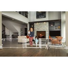 a woman standing in front of a living room filled with furniture and a fire place