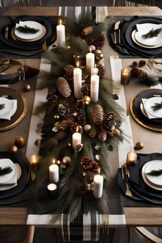 the table is set with black and white plates, silverware, pine cones, and candles