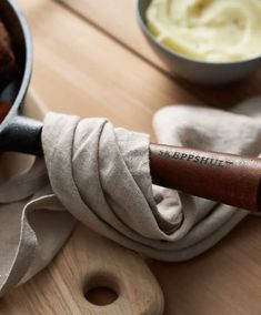 a wooden spatula sitting on top of a table next to a pot filled with food