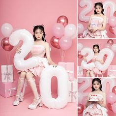 a woman in a pink dress sitting on top of a number 20 balloon with balloons around her