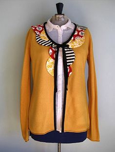 a woman's yellow cardigan with black and white trim