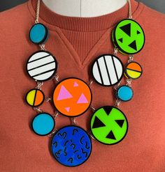 Patterned necklace is a quirky, fun accessory. It would look great as a statement piece to complete your everyday outfit. The necklace is made from multiple pieces of coloured perspex. These are layered on a clear background and have a bold black outline. They are all linked to a curb chain using jump rings.  If you have any questions drop us a line.💌 We are more than happy to help.😁 To clean your necklace you can simply wipe with a glasses cloth or soft cloth to remove finger marks. Acrylic is a fragile material so please store in a jewellery box to prevent damage.  As ever for safety please keep away from small children. Retro White Necklace For Party, White Retro Party Necklace, Multicolor Lucite Jewelry Gift, Multicolor Lucite Jewelry As Gift, Multicolor Lucite Jewelry For Gift, Playful Green Plastic Jewelry, Fun Plastic Jewelry For Party, Modern Resin Jewelry For Party, Modern Resin Jewelry For Parties