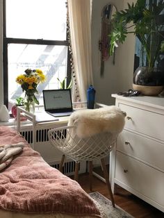 a bedroom with a bed, desk and chair in front of a window that has sunflowers on it